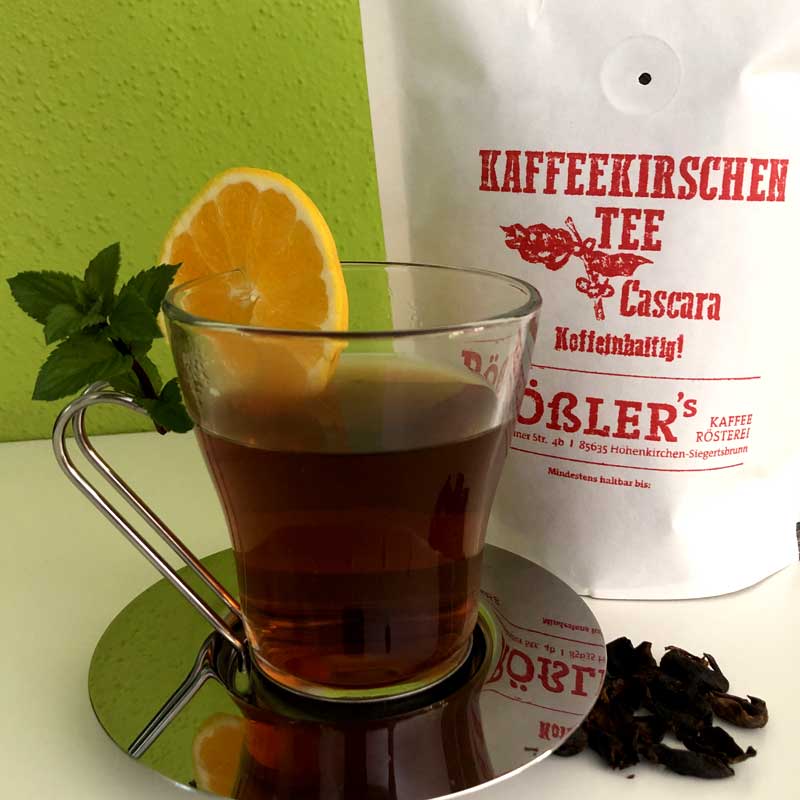 Kaffeekirschentee im Teeglas mit Minze und Orange